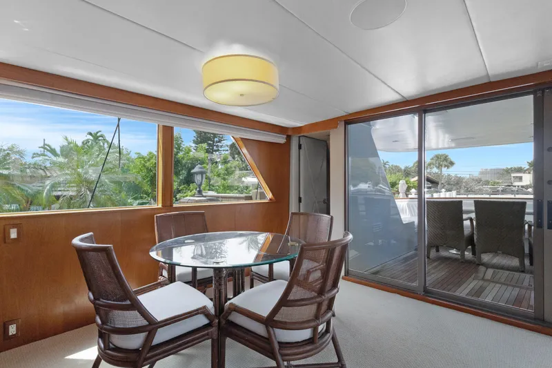 Slide: The Image of Luxurious yacht interior with glass table, wicker chairs, and large windows, Burger 1985 model. - 4