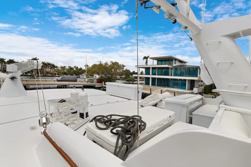 Slide: The Image of Luxury yacht deck with ropes, docked near modern waterfront home, under a partly cloudy sky. - 41