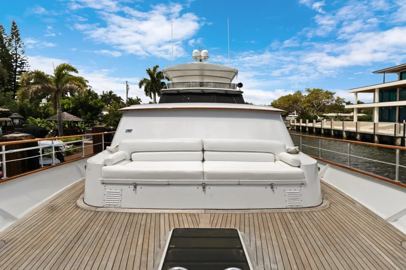 Slide: The Image of Luxury 1985 Burger yacht with spacious deck and white seating, docked by waterfront homes. - 47