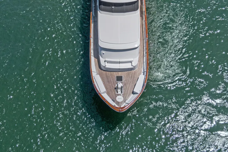 Slide: The Image of Aerial view of 1985 Burger yacht cruising on sparkling green water. - 49
