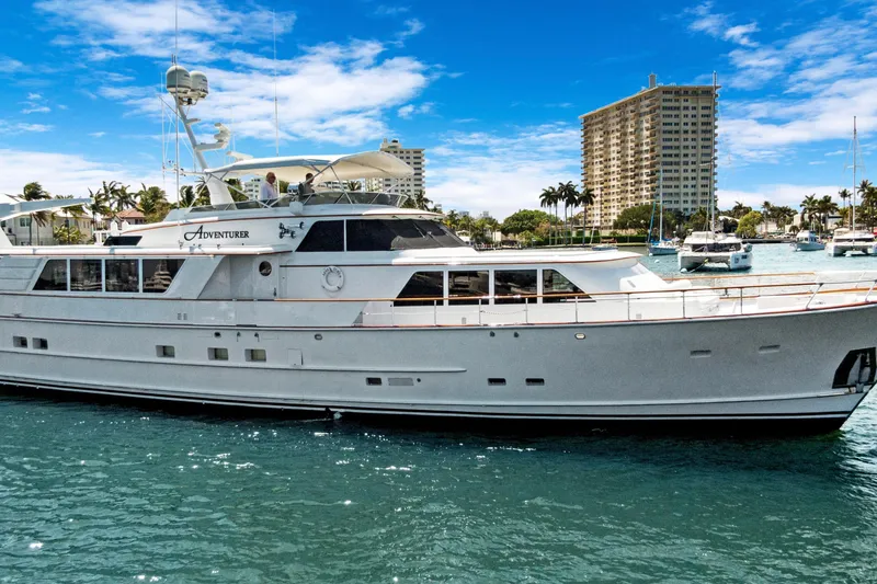Slide: The Image of Luxury yacht "Adventurer" docked in a marina, clear blue sky, 1985 Burger model. - 52
