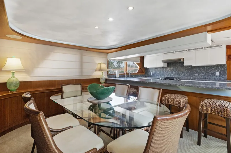 Slide: The Image of Luxurious yacht dining area with glass table, elegant chairs, and modern kitchen, Burger 1985 model. - 8