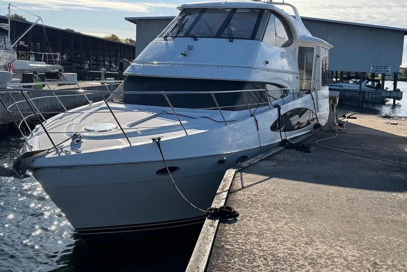 Slide: The Image of 2000 Carver 506 Motor Yacht docked at marina under clear sky. - 2