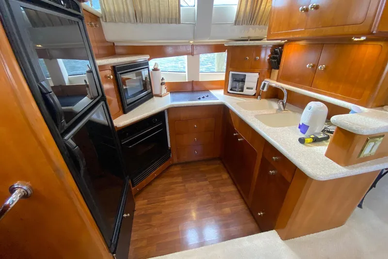 Slide: The Image of Luxurious kitchen interior of 2000 Carver 506 Motor Yacht with wood cabinetry and modern appliances. - 23