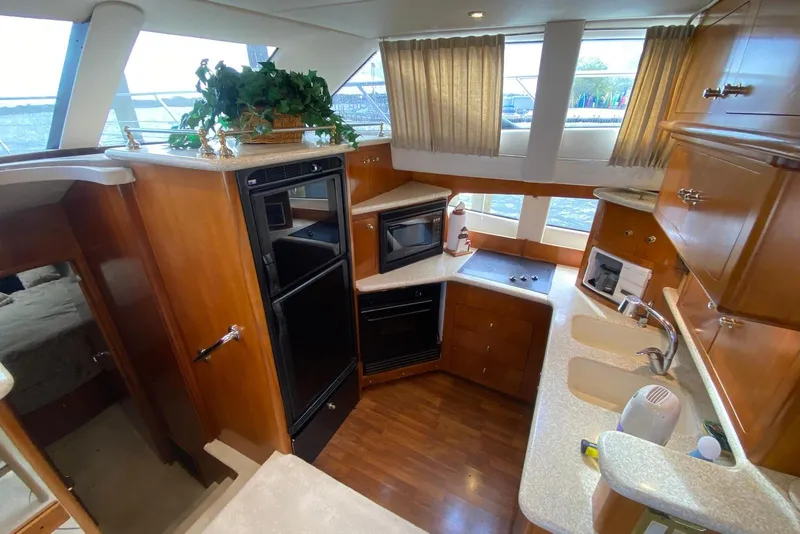 Slide: The Image of Interior of 2000 Carver 506 Motor Yacht kitchen with wood cabinetry and modern appliances. - 24