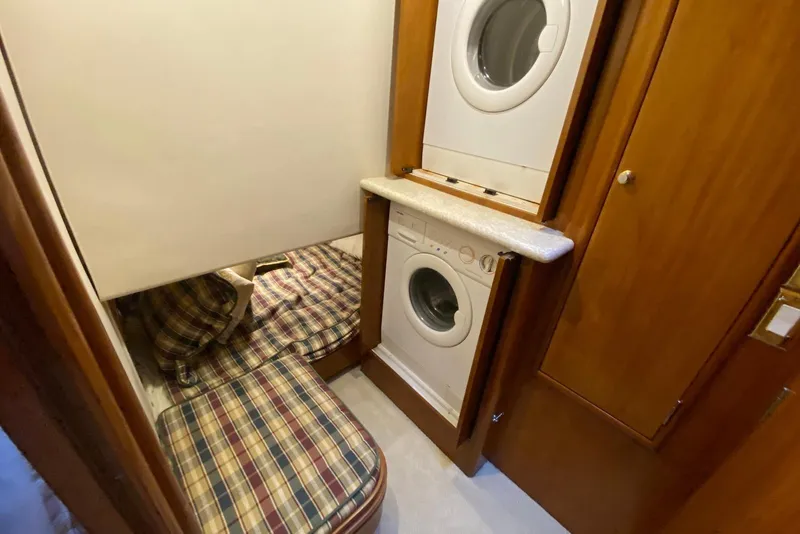 Slide: The Image of Laundry area in 2000 Carver 506 Motor Yacht with washer, dryer, and plaid bedding. - 28