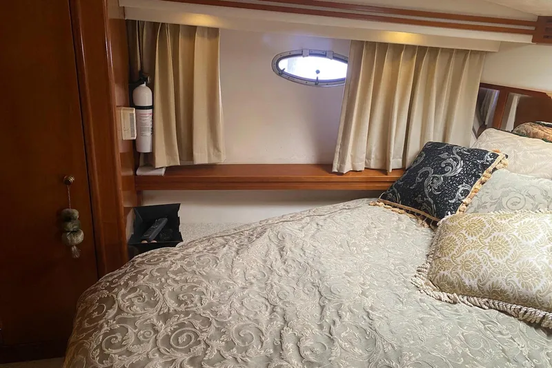 Slide: The Image of Luxurious bedroom interior of 2000 Carver 506 Motor Yacht with elegant bedding and porthole. - 30