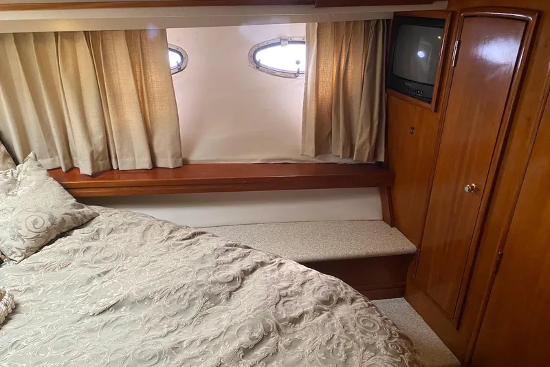 Slide: The Image of Interior of 2000 Carver 506 Motor Yacht with bed, curtains, and TV. - 31