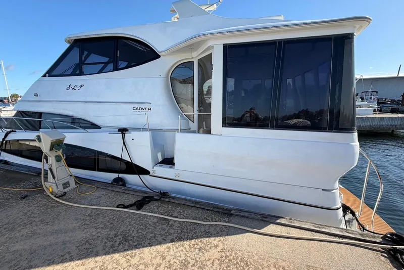 Slide: The Image of 2000 Carver 506 Motor Yacht docked, showcasing sleek design and spacious cabin. - 4