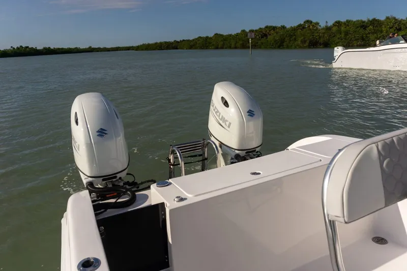 Slide: The Image of Twin Vee 240 STX CC 2026 with Suzuki outboard motors on calm water. - 14