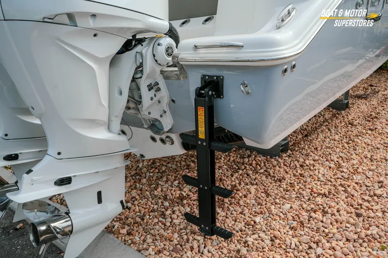 Slide: The Image of 2026 Key West 291 FS boat with dual outboard motors on rocky ground. - 7