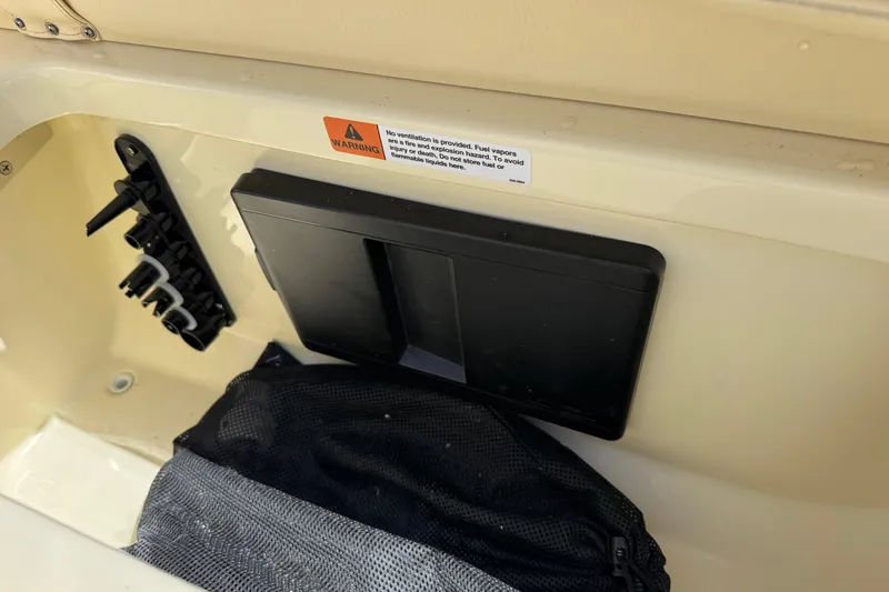 Slide: The Image of Interior detail of 2026 Chris-Craft Sportster 28 boat with warning label and storage compartment. - 10