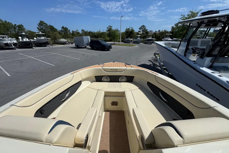 Slide: The Image of 2026 Chris-Craft Sportster 28 boat interior with beige seating in a parking lot. - 18