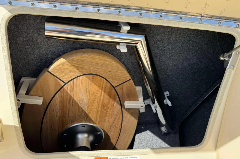 Slide: The Image of Storage compartment in a 2026 Chris-Craft Sportster 28, featuring a wooden table and metal pole. - 23