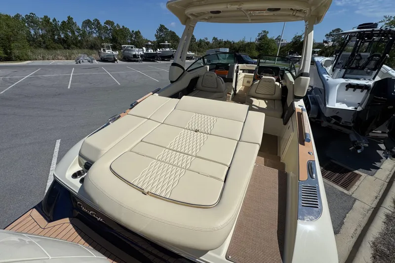 Slide: The Image of 2026 Chris-Craft Sportster 28 boat with luxurious seating in a marina parking area. - 7