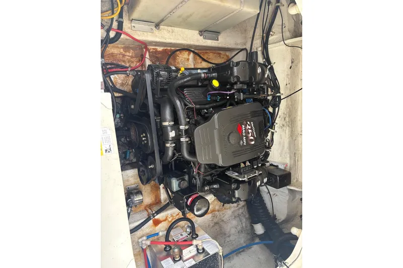 Slide: The Image of Engine compartment of a 2006 Larson Cabrio 260 boat, showcasing the motor and wiring. - 11