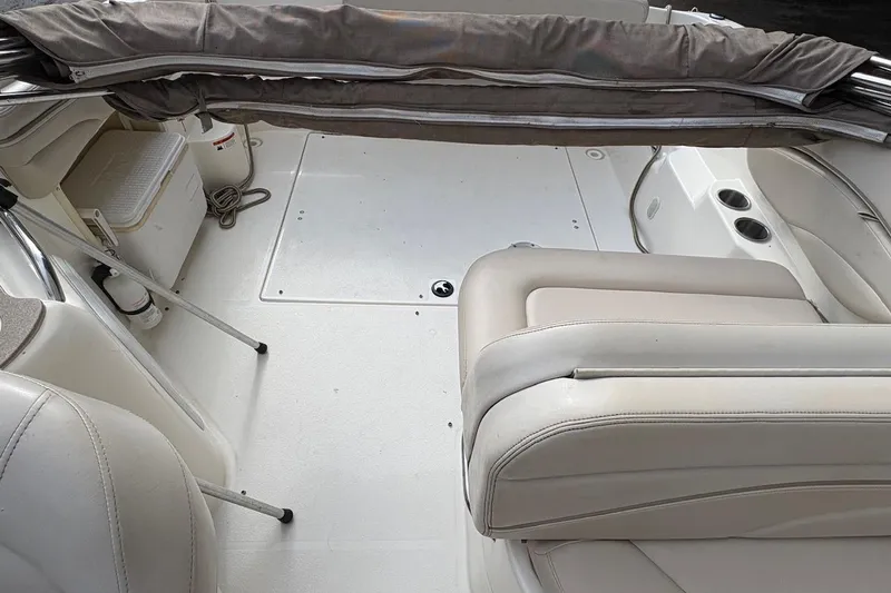 Slide: The Image of 2006 Larson Cabrio 260 boat interior with beige seating and storage compartments. - 13