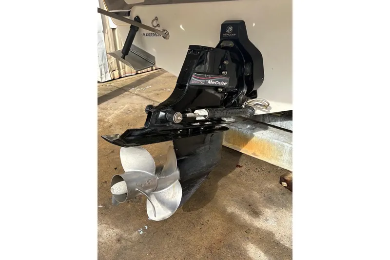 Slide: The Image of 2006 Larson Cabrio 260 boat with MerCruiser outdrive and propeller, parked on concrete. - 15