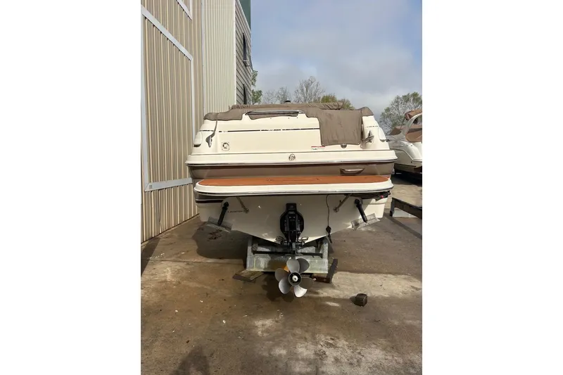 Slide: The Image of 2006 Larson Cabrio 260 boat on trailer, rear view, parked outdoors. - 2