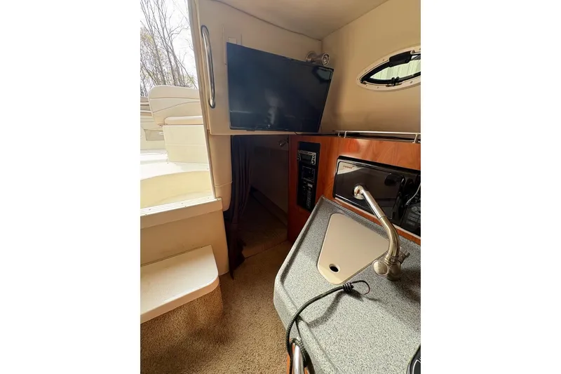 Slide: The Image of Interior of 2006 Larson Cabrio 260 boat with TV, sink, and seating area. - 5
