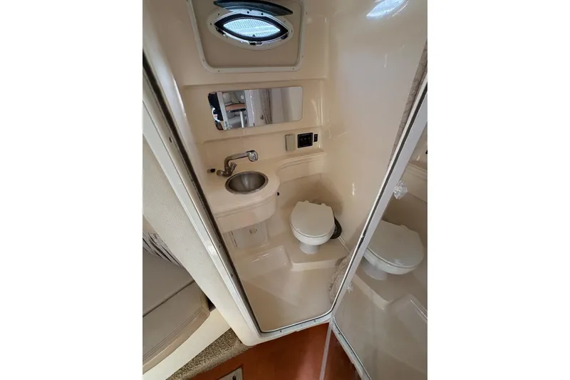 Slide: The Image of 2006 Larson Cabrio 260 boat bathroom with sink, toilet, and mirror. - 6