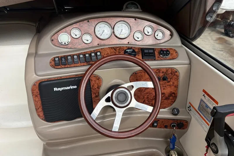 Slide: The Image of 2006 Larson Cabrio 260 dashboard with wood accents and Raymarine navigation system. - 9