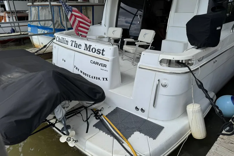 Slide: The Image of 1999 Carver 450 Voyager Pilothouse docked, displaying "Chillin The Most" and American flag. - 11