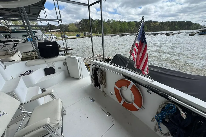 Slide: The Image of 1999 Carver 450 Voyager Pilothouse docked, featuring American flag and life preserver. - 13