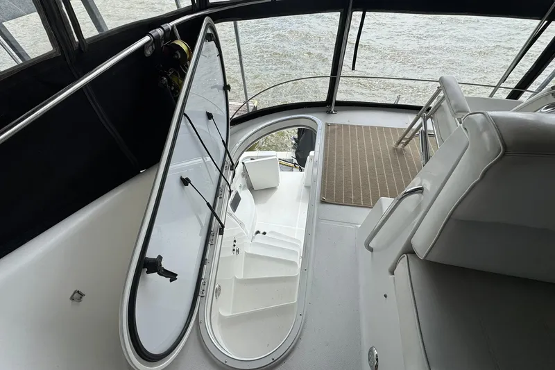 Slide: The Image of 1999 Carver 450 Voyager Pilothouse interior with open hatch and seating area. - 14
