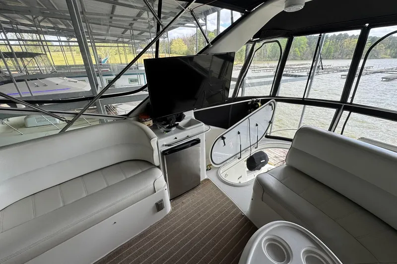 Slide: The Image of Interior of 1999 Carver 450 Voyager Pilothouse with seating, TV, and water view. - 17