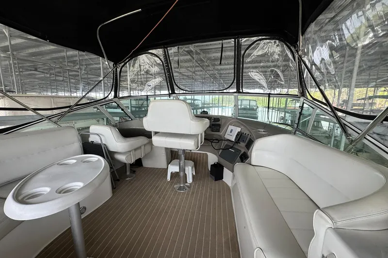 Slide: The Image of 1999 Carver 450 Voyager Pilothouse interior with seating and helm, docked under cover. - 18