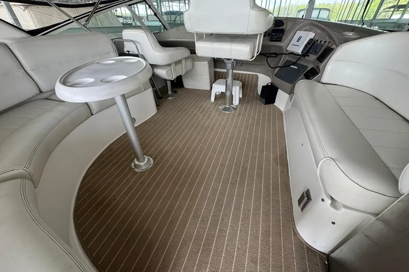 Slide: The Image of Interior of a 1999 Carver 450 Voyager Pilothouse with white seating and a small table. - 20