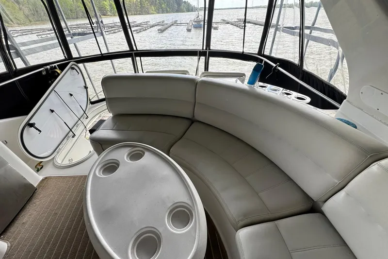 Slide: The Image of Interior of 1999 Carver 450 Voyager Pilothouse with curved seating and table, overlooking marina. - 22