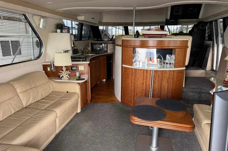 Slide: The Image of Interior of 1999 Carver 450 Voyager Pilothouse with beige seating and wooden cabinetry. - 27