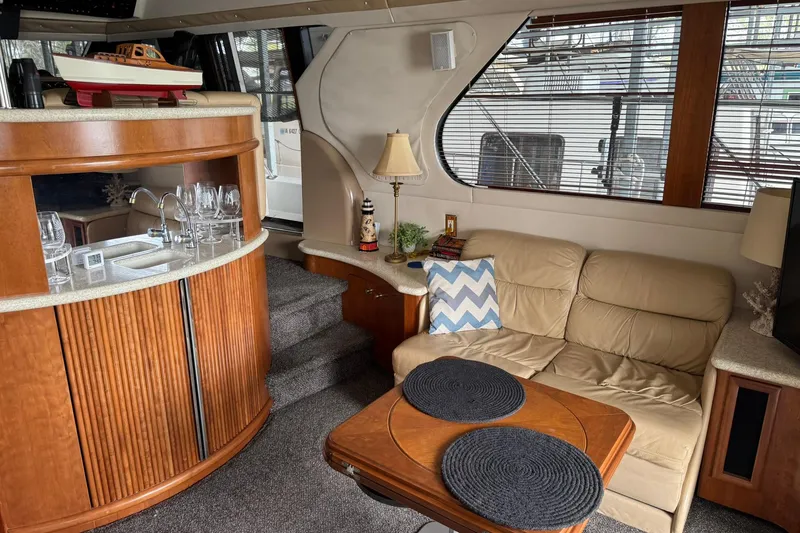 Slide: The Image of Interior of 1999 Carver 450 Voyager Pilothouse with cozy seating and elegant bar area. - 28