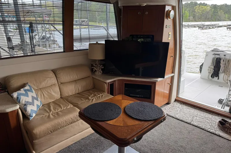 Slide: The Image of Interior of 1999 Carver 450 Voyager Pilothouse with sofa, TV, and lake view. - 29