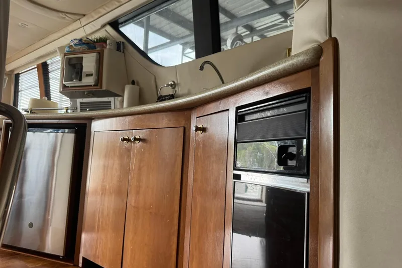 Slide: The Image of Interior of 1999 Carver 450 Voyager Pilothouse with wooden cabinetry and appliances. - 33