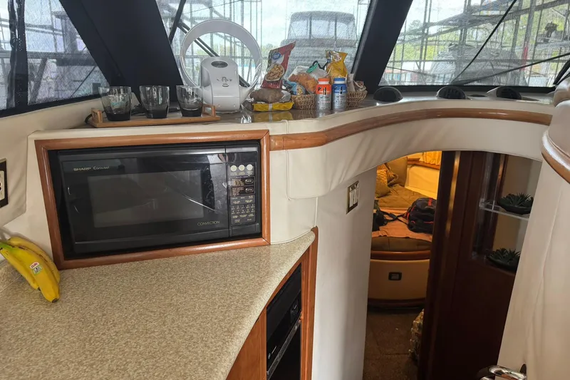 Slide: The Image of Interior of 1999 Carver 450 Voyager Pilothouse with microwave and snacks on counter. - 34