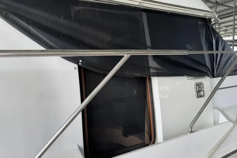Slide: The Image of 1999 Carver 450 Voyager Pilothouse yacht with black canvas cover and stainless steel railing. - 4