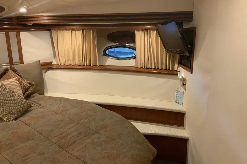 Slide: The Image of Interior of 1999 Carver 450 Voyager Pilothouse with bed, porthole, and TV. - 60