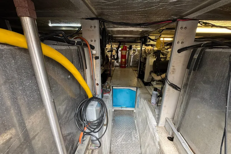 Slide: The Image of Engine room of a 1999 Carver 450 Voyager Pilothouse with visible wiring and equipment. - 67