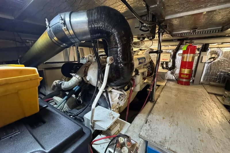 Slide: The Image of Engine room of a 1999 Carver 450 Voyager Pilothouse with visible machinery and fire extinguisher. - 69