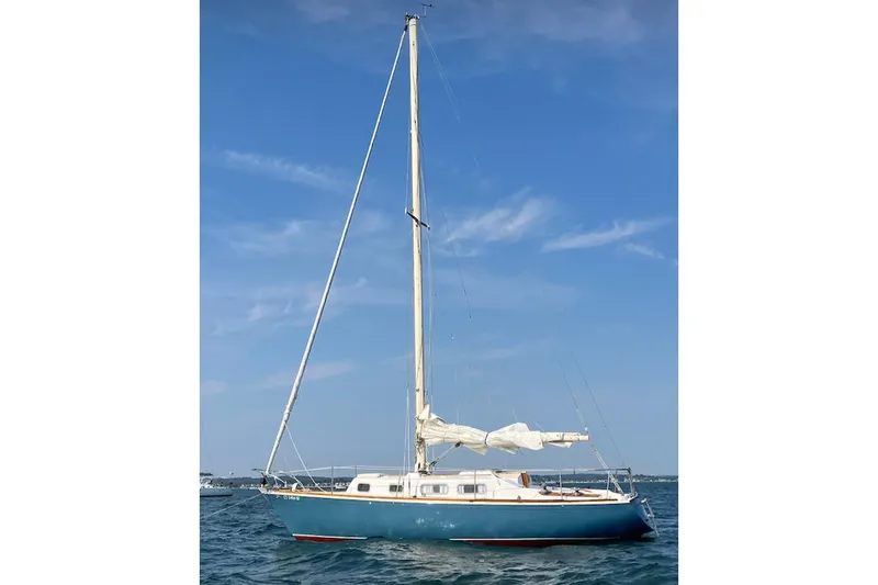 Slide: The Image of 1974 Tartan Sloop sailboat on calm blue water under clear sky. - 6