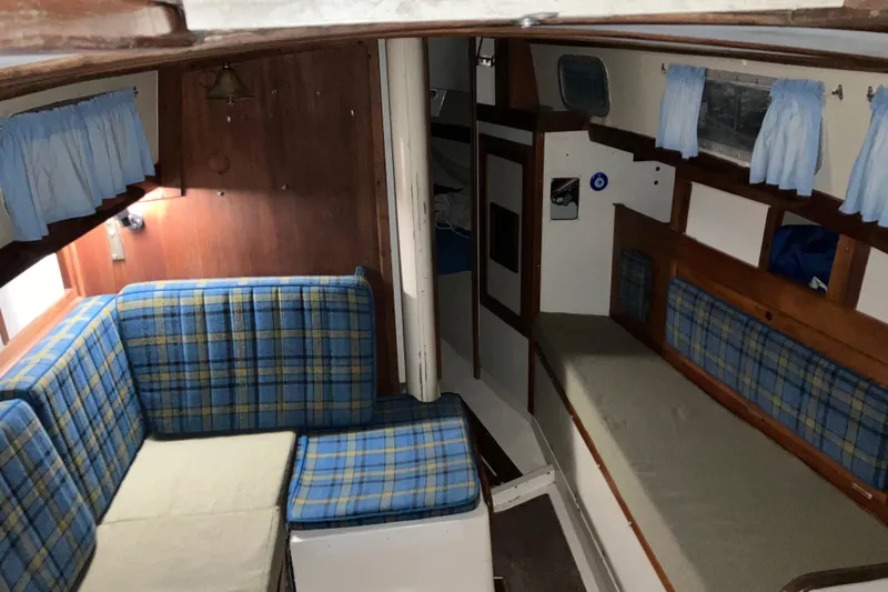 Slide: The Image of Interior of a 1974 Tartan Sloop sailboat with plaid seating and wooden accents. - 8