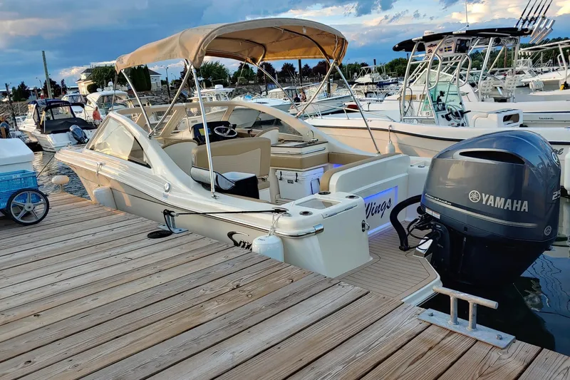 The Image of 2019 Scout 235 Dorado boat docked with Yamaha outboard motor, under a cloudy sky. - 0