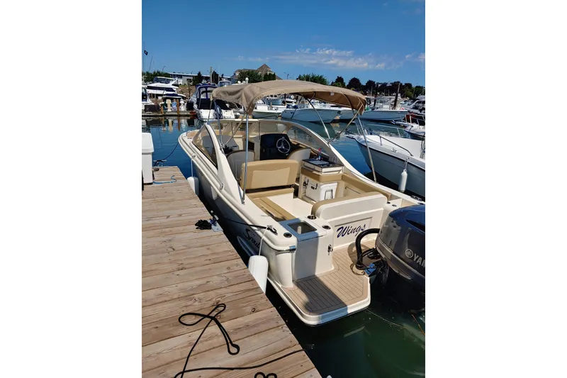 Slide: The Image of 2019 Scout 235 Dorado boat docked at marina with canopy and Yamaha engine. - 2
