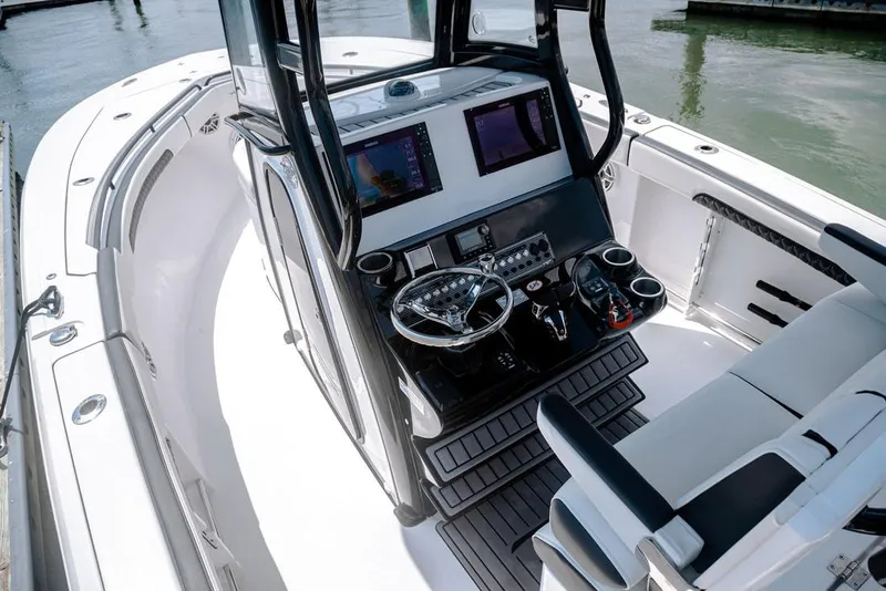 Slide: The Image of Control panel of 2023 Tidewater 282 CC Adventure Bluewater boat with steering wheel and electronics. - 14