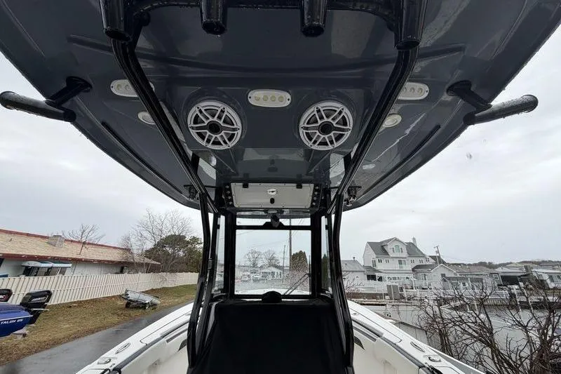 Slide: The Image of 2023 Tidewater 282 CC Adventure Bluewater boat with speakers and rod holders on the T-top. - 26