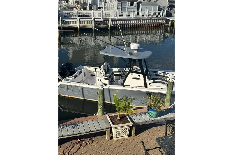 Slide: The Image of 2023 Tidewater 282 CC Adventure Bluewater boat cruising on a lake under a cloudy sky. - 4