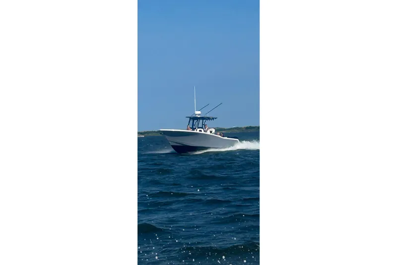 Slide: The Image of 2023 Tidewater 282 CC Adventure Bluewater boat docked by waterfront homes. - 5